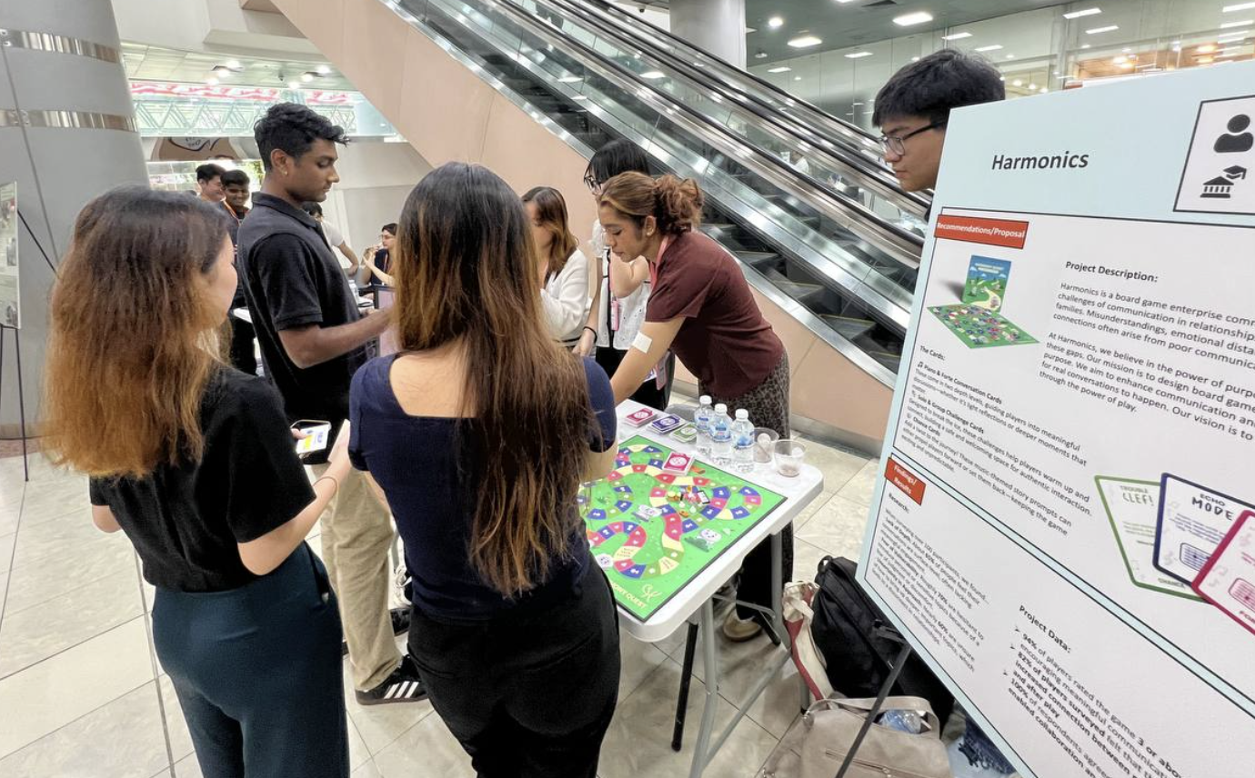 Visitors exploring the Harmonics booth and display board at a community event.