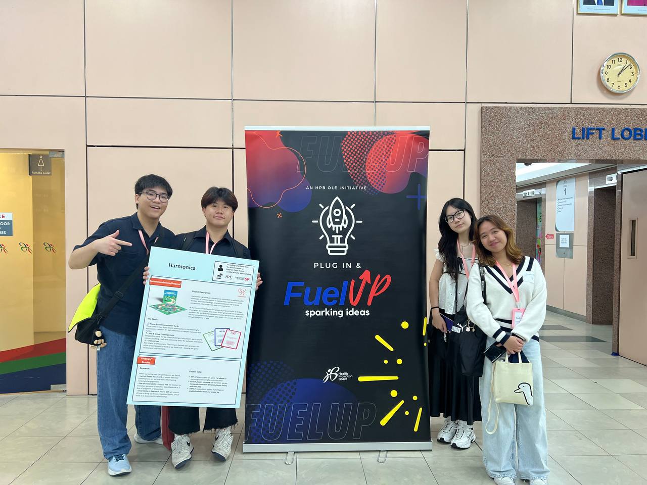 The Harmonics team at the Health Promotion Board Plug In & Fuel Up activation, standing beside the FuelUp banner.